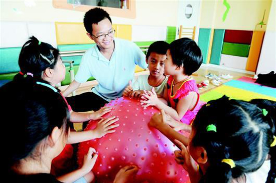 图为：趁着回乡探亲的机会，孙小辉与荆州市残联康复学校的孩子们互动 通讯员梅闻摄