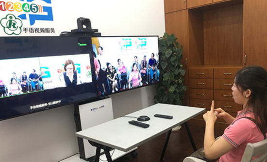 上海市宝山区居民黄女士在视频前通过手语向上海12345市民服务热线建议在医院增设手语翻译岗位，协助聋人挂号等事务，视频里的服务人员正实时跟她互动。 澎湃新闻记者 臧鸣 图