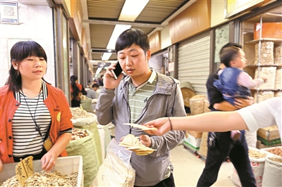 4 2017年5月7日，李春阳在成都荷花池中药材专业市场批发药材。