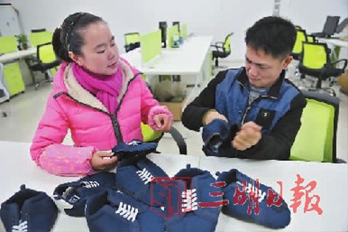 彭娥飞在教残疾人做鞋面手工活。