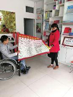何继伟和妻子正在查看刚打印出来的宣传广告